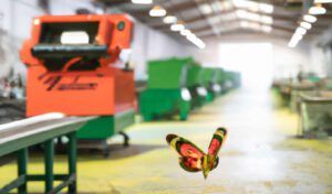 Una mariposa sobrevuela un taller de fabricación simbolizando los problemas en la planificación de la producción