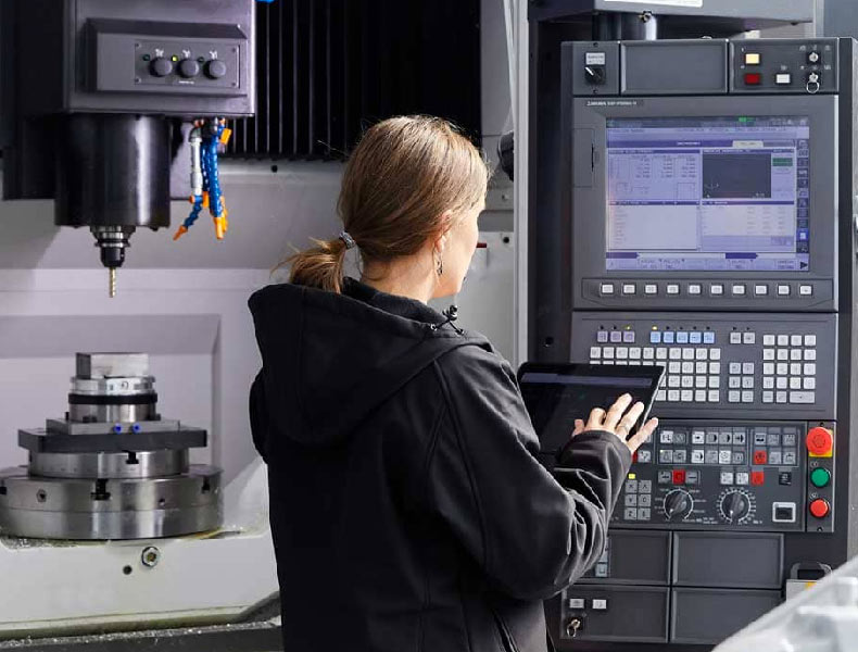 Técnico analizando un proceso industrial frente a una máquina de mecanizado